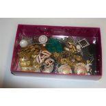 A box containing buttons, a turquoise pendant, ear