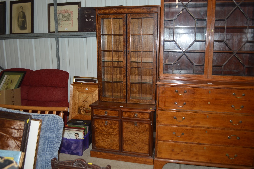 A walnut bookcase raised on cupboard base