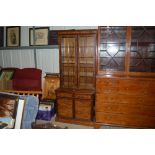 A walnut bookcase raised on cupboard base