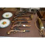Seven replica pistols and a powder flask