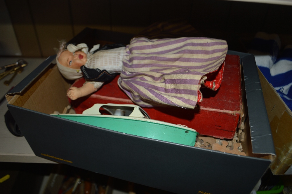 A box containing a two headed doll; a wooden puzzl