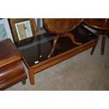 A teak and glass topped two tier coffee table