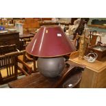 A large brass table lamp with red shade