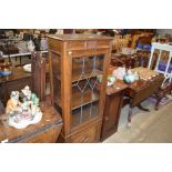 An oak and leaded glazed display cabinet of narrow