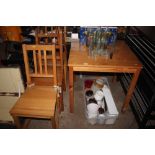 A square topped pine table with three pine dining