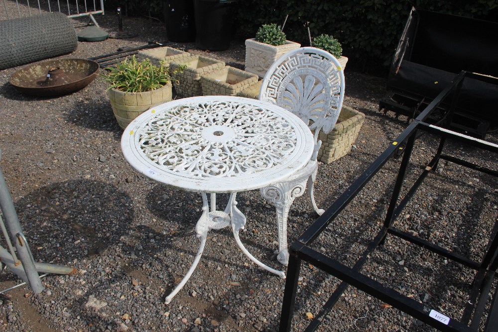 A metal garden table with one matching chair