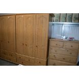 A pine effect triple wardrobe fitted five drawers
