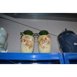 A pair of twin handled floral decorated vases, one