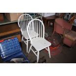 A pair of white painted stick back dining chairs