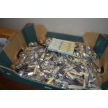 A box of various stainless steel cutlery