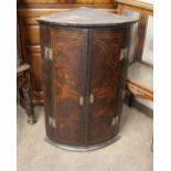 An 18th Century japanned lacquered elliptical corner cupboard, decorated in the chinoiserie