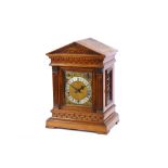 A late Victorian oak chiming bracket clock, the temple case enclosing a brass spandrel dial with