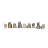 A collection of various silver and white metal thimbles, including filigree work examples