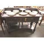 An Antique oak serving table, having raised shaped back above two geometric moulded panel front