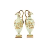 A pair of Grainger & Co., Worcester baluster ewers, having rich gilt foliate decoration on a pale