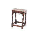An antique oak joint stool, rectangular top on a shaped frieze, raised on baluster turnedsupports
