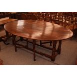 A large good quality oak gate leg dining table, in the 18th Century style, the rounded drop leaves