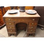 A Georgian oak knee-hole desk, fitted with a long frieze drawer above a central cupboard, flanked by