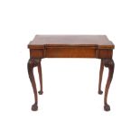 A Georgian mahogany card table, the fold-over canted corner top raised on carved shoulders and