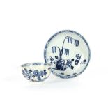 An 18th Century blue and white porcelain tea bowl and saucer, with floral spray decoration; and