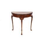 A 20th Century walnut demi-lune fold over card table, raised on cabriole supports, 57cm wide