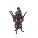 A Chinese bronze censer, the lid surmounted by a Dog of Fo, flanked by loop handles with raised