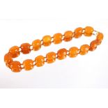 An amber necklace with gold clasp, eighteen beads