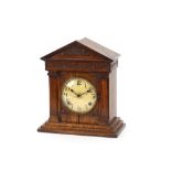 An early 20th Century oak cased mantel clock, of temple design, having 8 day movement striking on