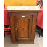 An antique oak hanging wall cupboard, the interior shelves enclosed by a single cross banded panel