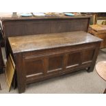A large Antique oak coffer, having quadruple panelled front, raised on square section supports,