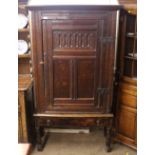 A large Antique oak storage cupboard, enclosed by a single carved panel door, single drawer to base,