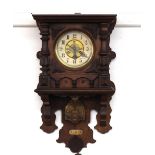 A late Victorian walnut cased wall clock, having leaf carved decoration to the case, circular dial