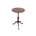 A circular mahogany occasional table, the dished top raised on turned and fluted baluster column and