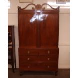 A Regency Irish mahogany linen press, surmounted by a scroll arch pediment with brass bosses,