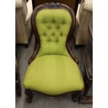 A Victorian walnut spoon back nursing chair, with green buttoned upholstery raised on cabriole front