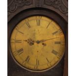 A long case clock, by Winstanley of Wirksworth, having circular brass dial, the carved case