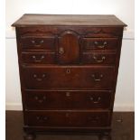 An 18th Century oak Norfolk chest, fitted central cupboard and four short drawers above three long