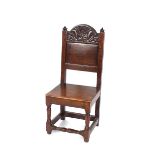 An antique oak hall chair, having carved panel back raised on turned supports united by stretchers