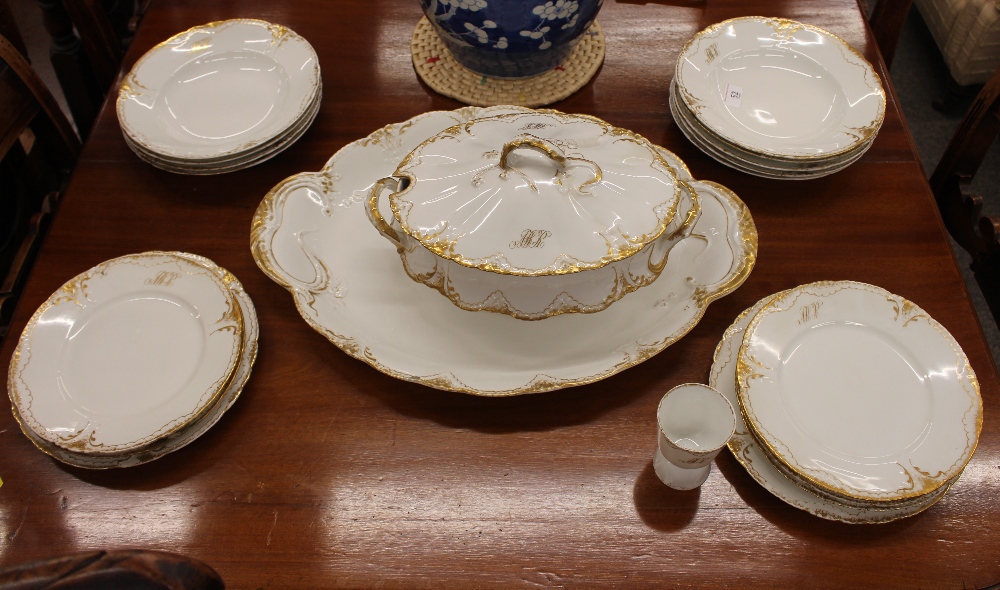 A Limoges part dinner service, monogrammed and with foliate gilt and berry decoration, (19)