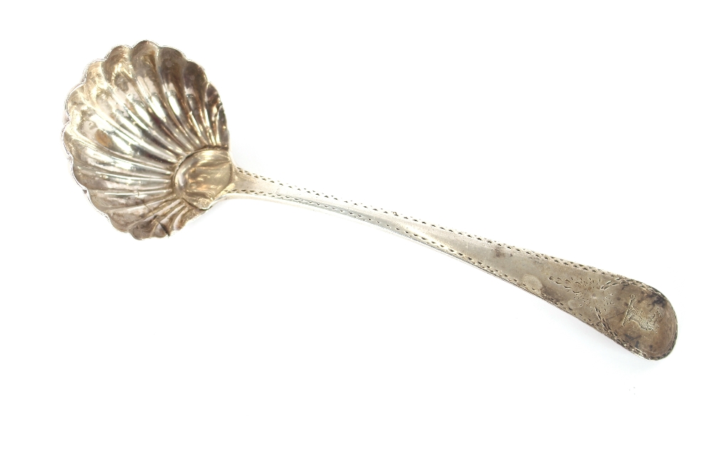 A George III silver sauce ladle, having fluted bowl, bearing family crest, London 1782