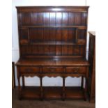 A good quality reproduction oak dresser, having shelved and boarded back fitted with two small