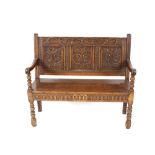 A Victorian carved oak bench, having foliate decorated triple panelled back and solid seat, raised
