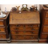 A Georgian oak and elm bureau, the fall front opening to reveal an interior arrangement of drawers