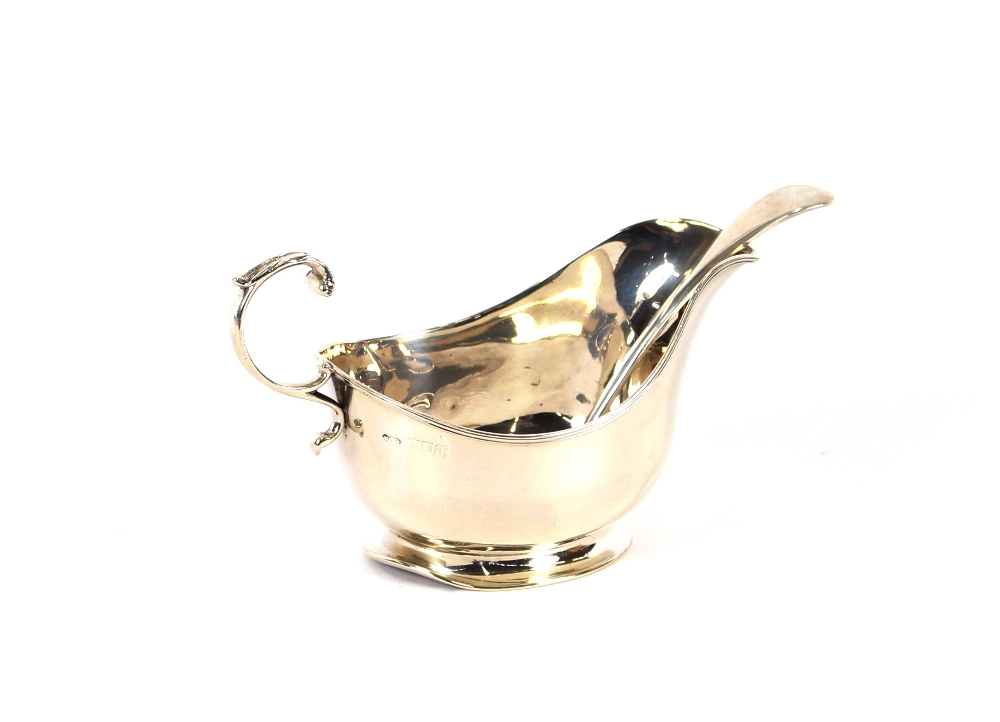 A silver cream jug, London 1915; and a silver sauce ladle, Birmingham 1921, (2)