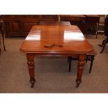 A Victorian mahogany extending dining table, fitted with an extra leaf raised on turned tapering