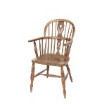 An elm Windsor elbow chair, having pierced splat back, raised on ring turned baluster tapering