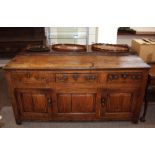 An 18th Century oak dresser base, fitted three drawers above fielded panelled doors, raised on