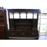 An Antique carved oak dresser, in the Jacobean style, having raised canopy back above cupboards