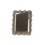 A French white metal mounted mirror, with embossed foliate scroll decoration, 27cm x 20cm