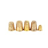 Five various gold and yellow metal thimbles